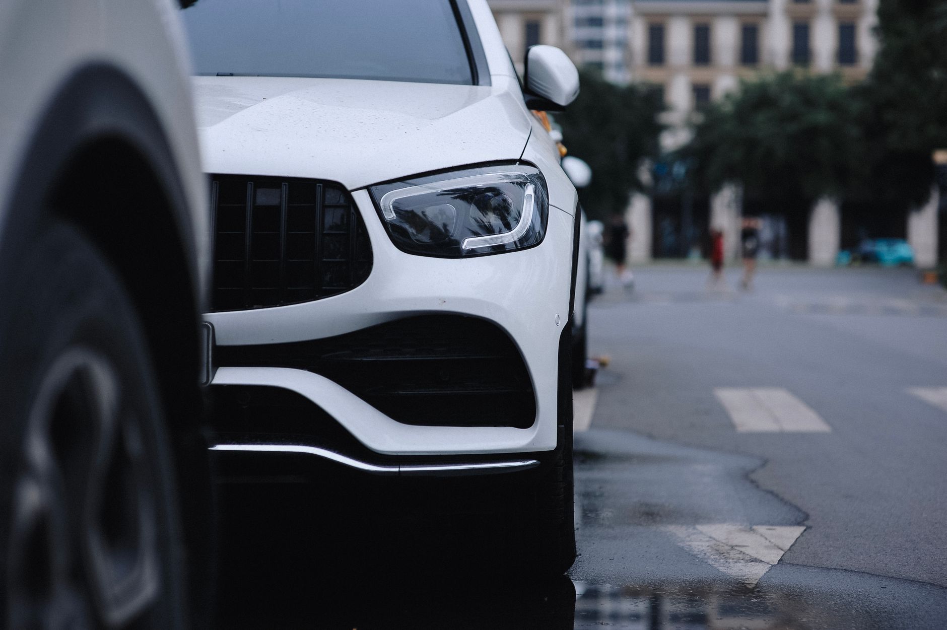 Close-up view of a sleek white car parked on a city street, reflecting urban style. — 5 Tips to Avoid Common Emergency Locksm