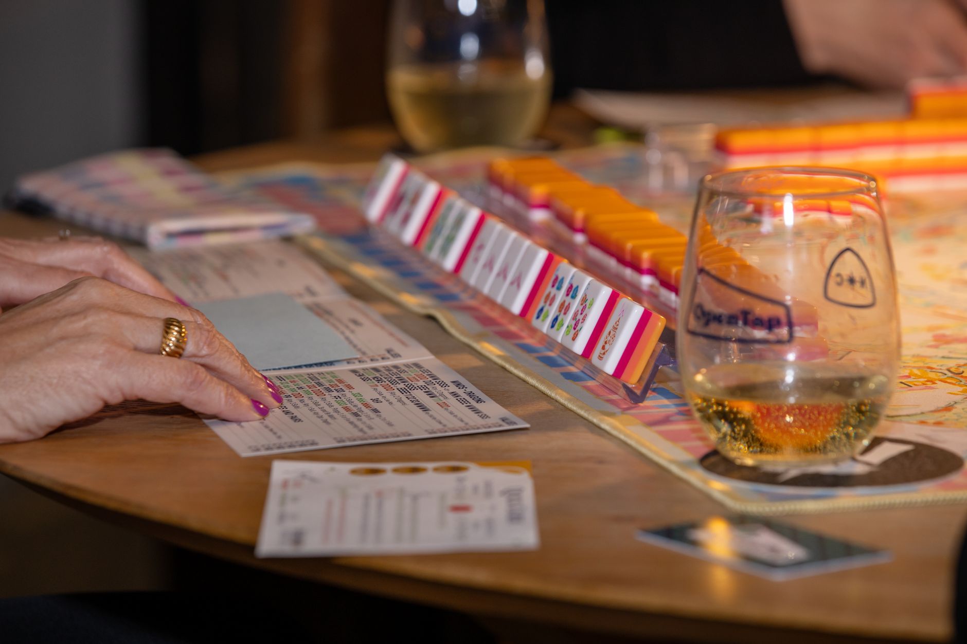 Engaging game night scene with friends playing mahjong and enjoying drinks. Perfect social moment. — Best Card Shows Charlott
