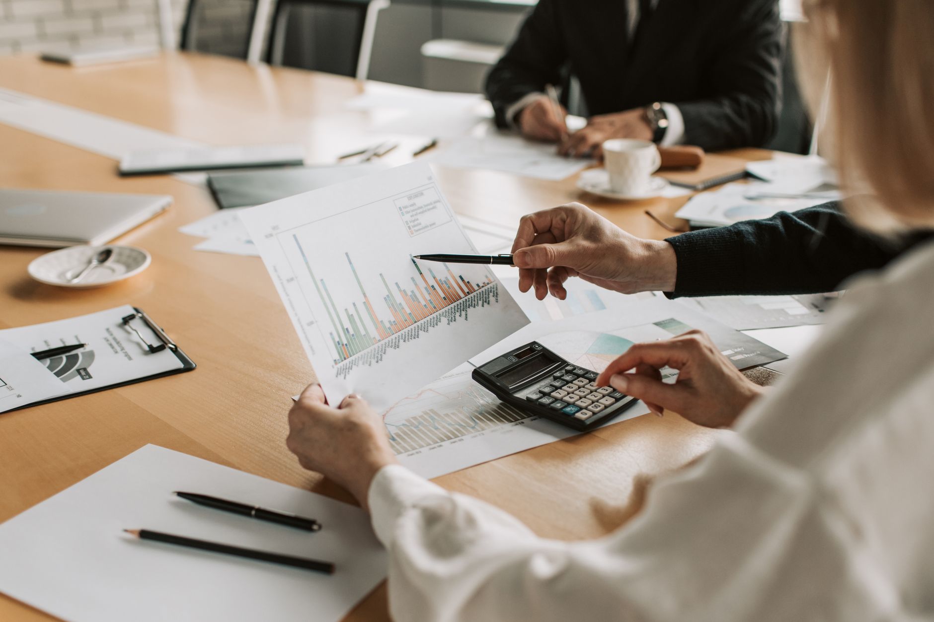 Professionals reviewing financial graphs and charts during a meeting. — How Futures Trading Discount Makes Funded Trading Mor