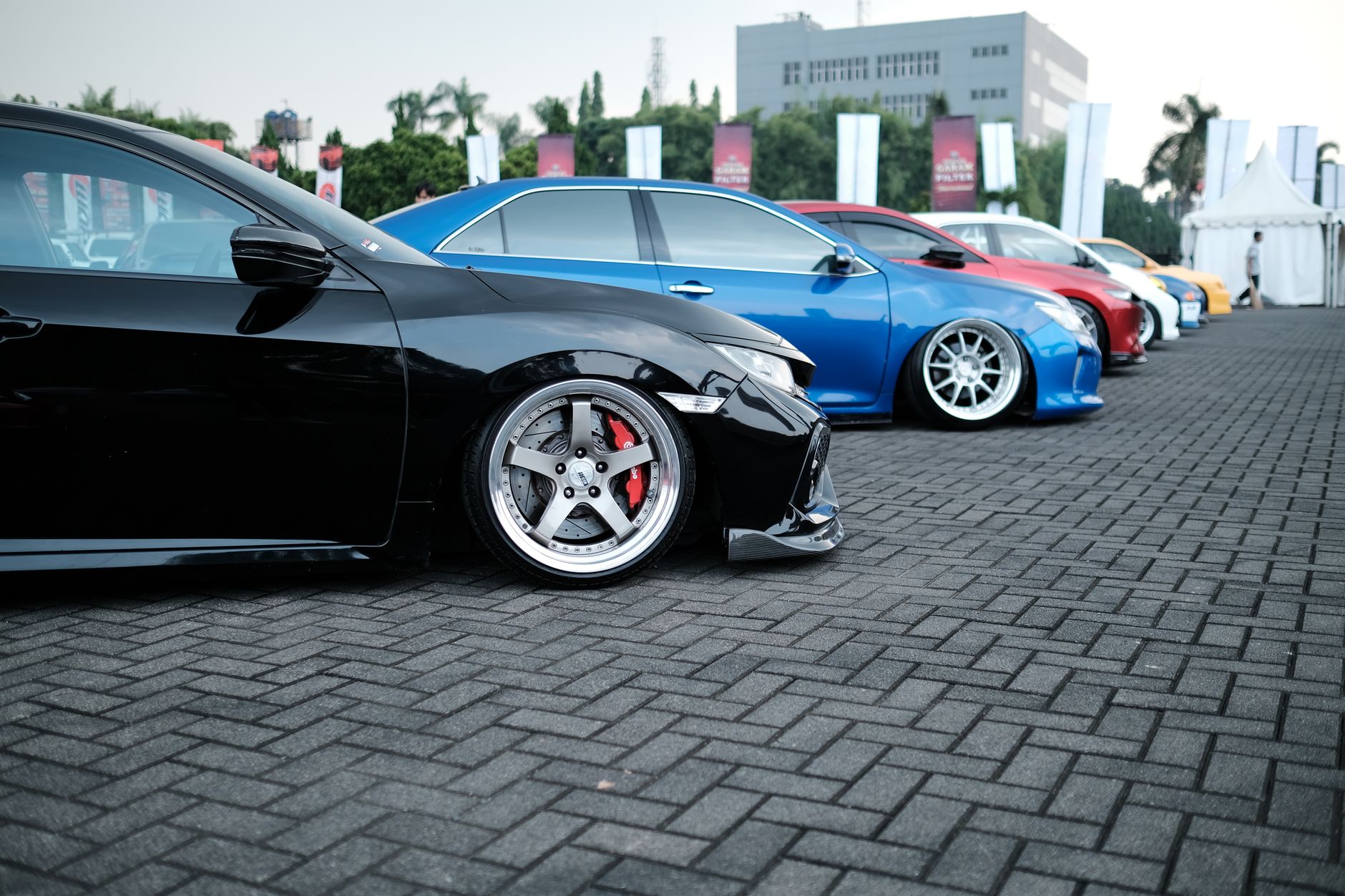 Showcase of sleek customized sports cars parked in an outdoor exhibition. — How To Buy Used Cars Fresno For Sale?