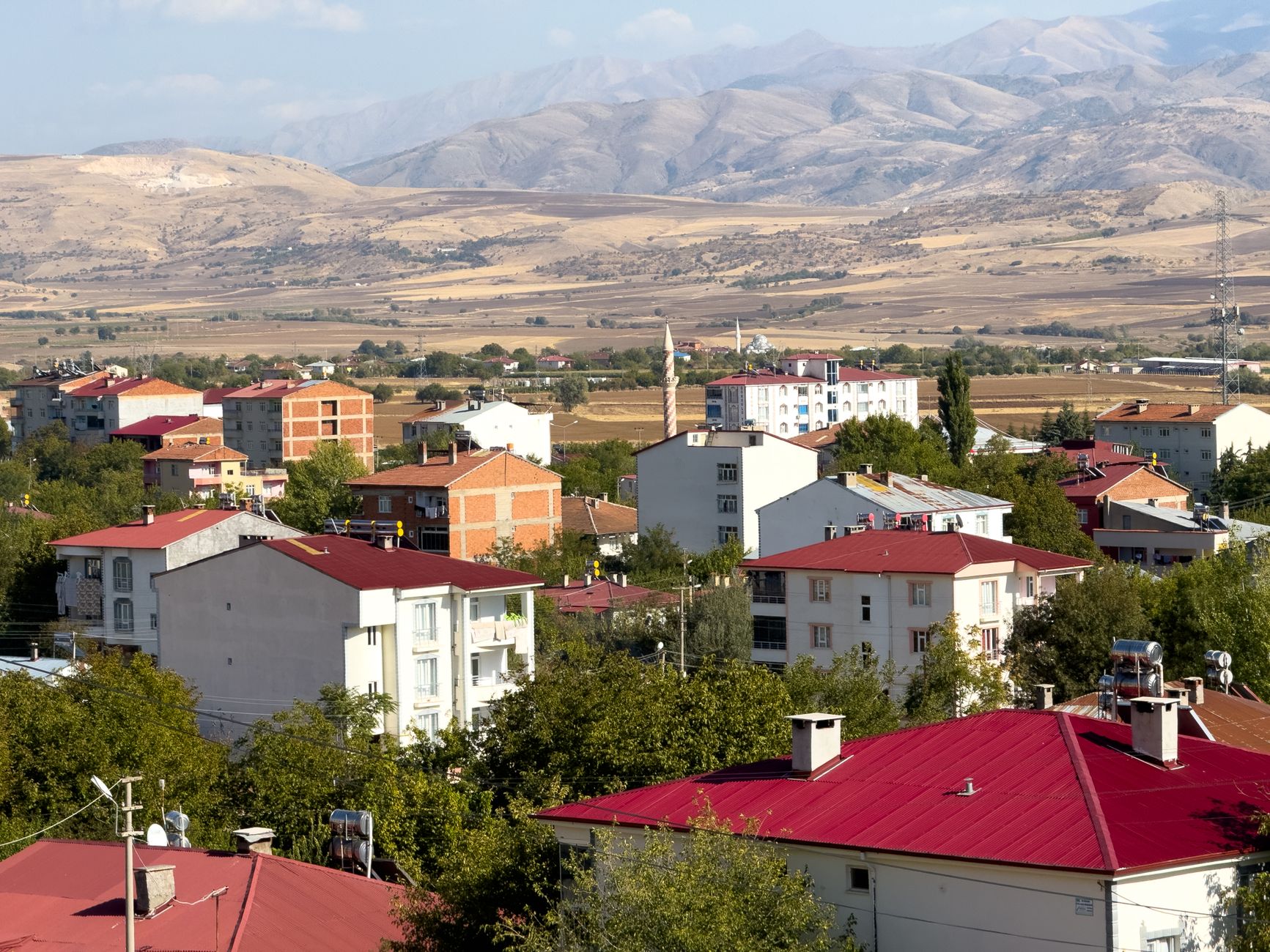 Panoramic view of Kovancılar town with red-roofed buildings against a backdrop of mountains in Elazığ, Türkiye. — How to find