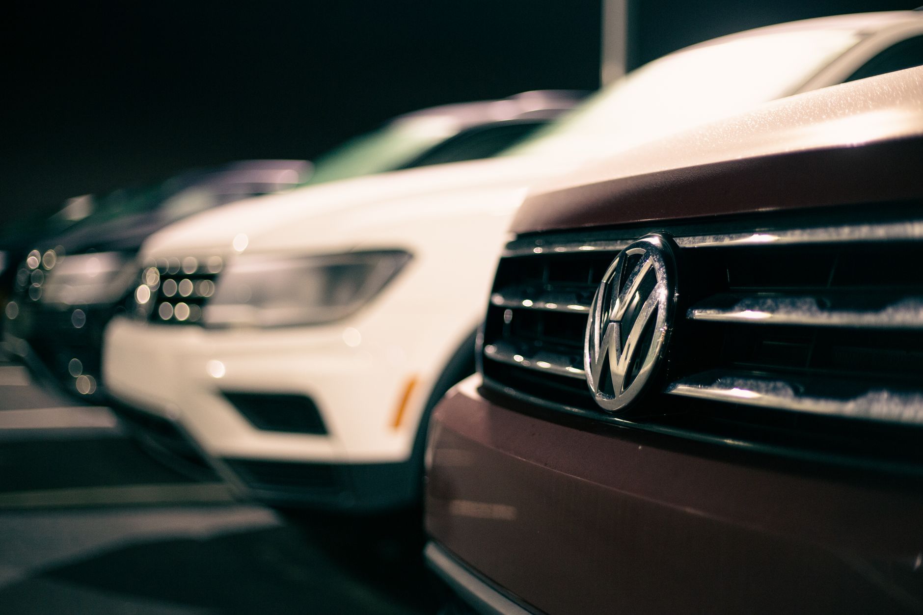 Front bumpers of expensive prestige automobiles at market retailing new cars at night — How To Find The Best Car Insurance In