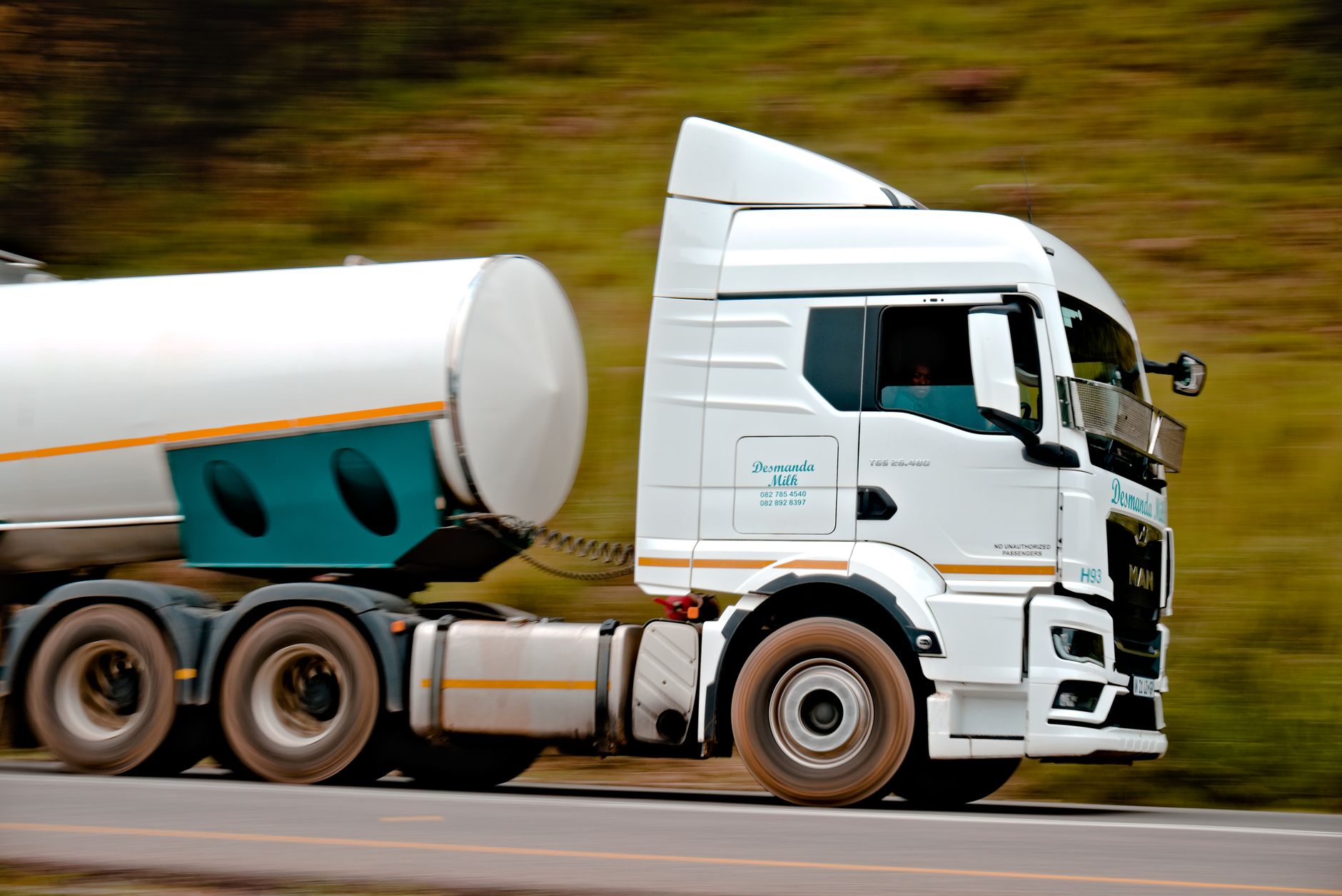 Close-up of a fast-moving white tanker truck on a highway, capturing motion and speed. — Kenworth Trucks - A Humble Starting