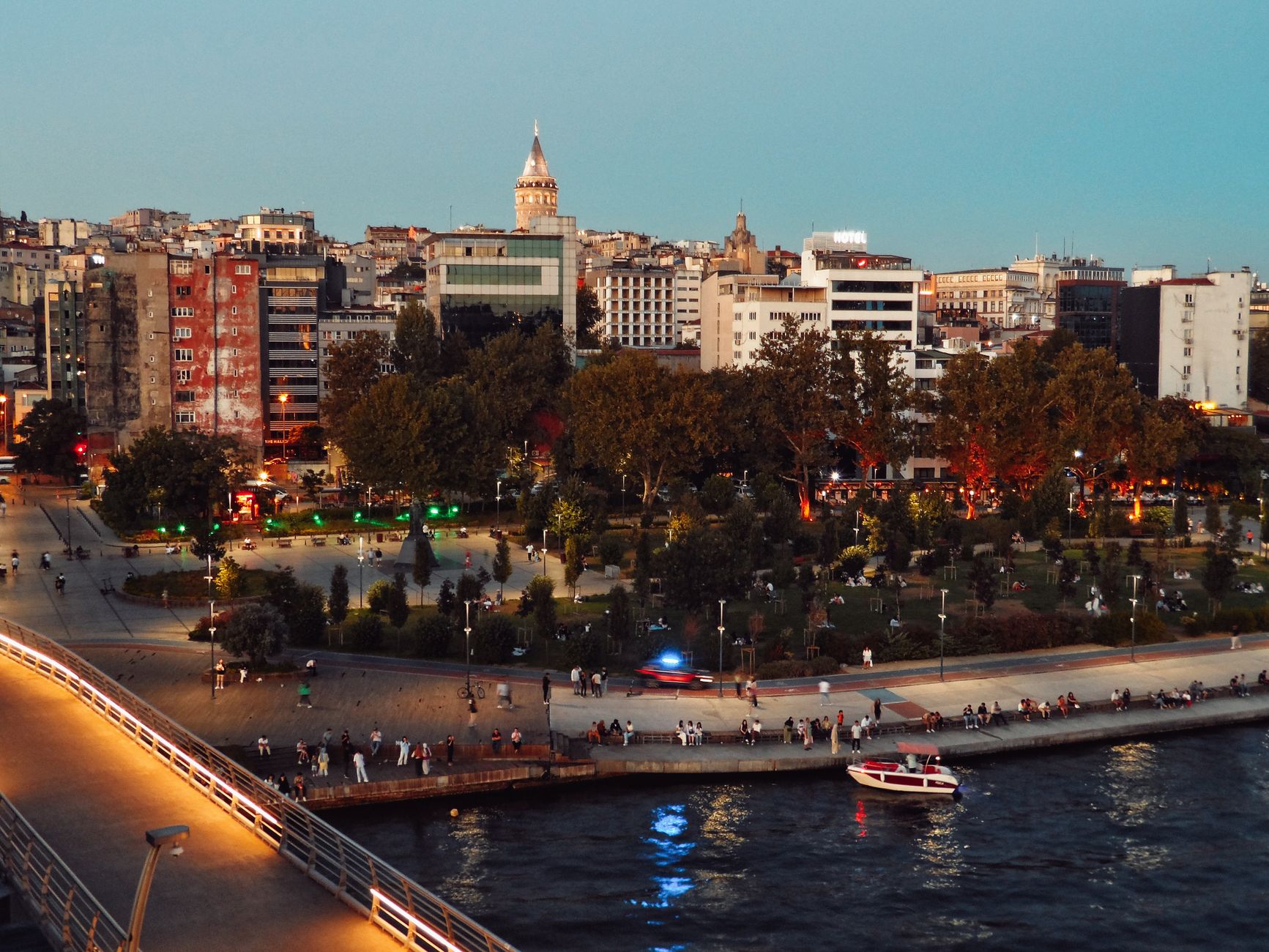 Scenic view of Istanbul's skyline featuring Galata Tower and bustling park at twilight along the waterfront. — Powder Coating