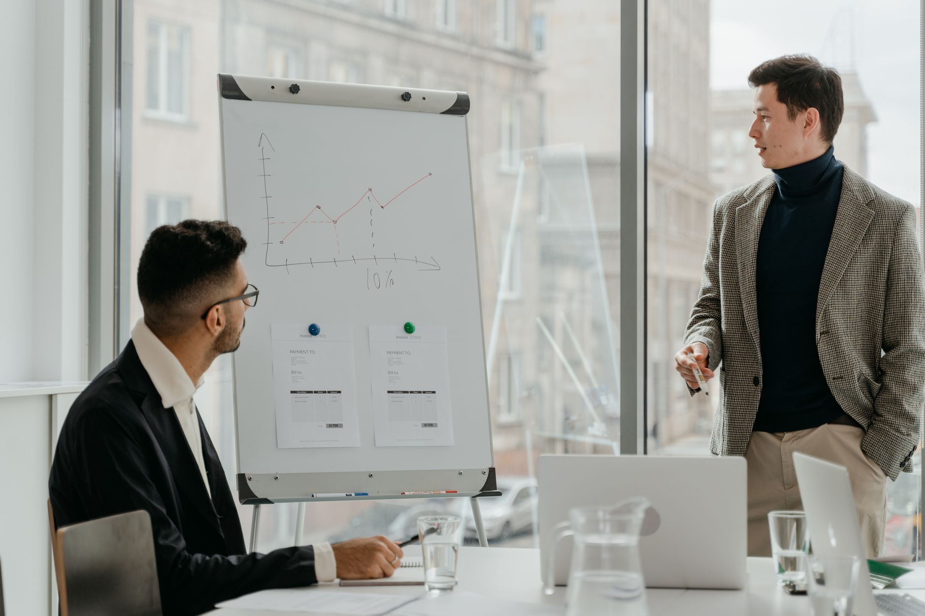 Professionals discussing a business chart in a modern office. — Rainy Day Hull Travel Plan for Work and School