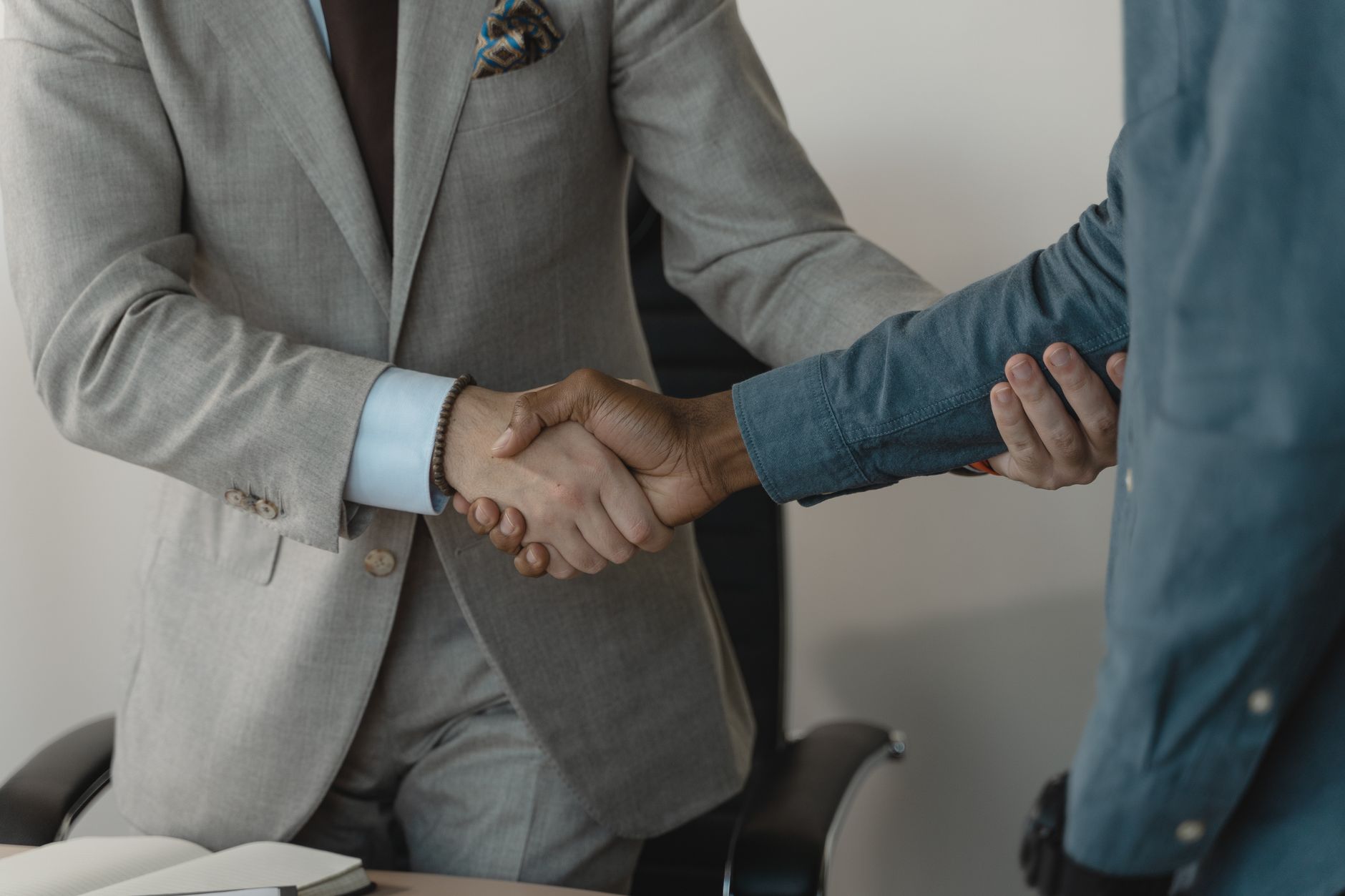 Image of a professional handshake between two businessmen in an office setting. — Rely on Oxford Taxis for Stress-Free City T