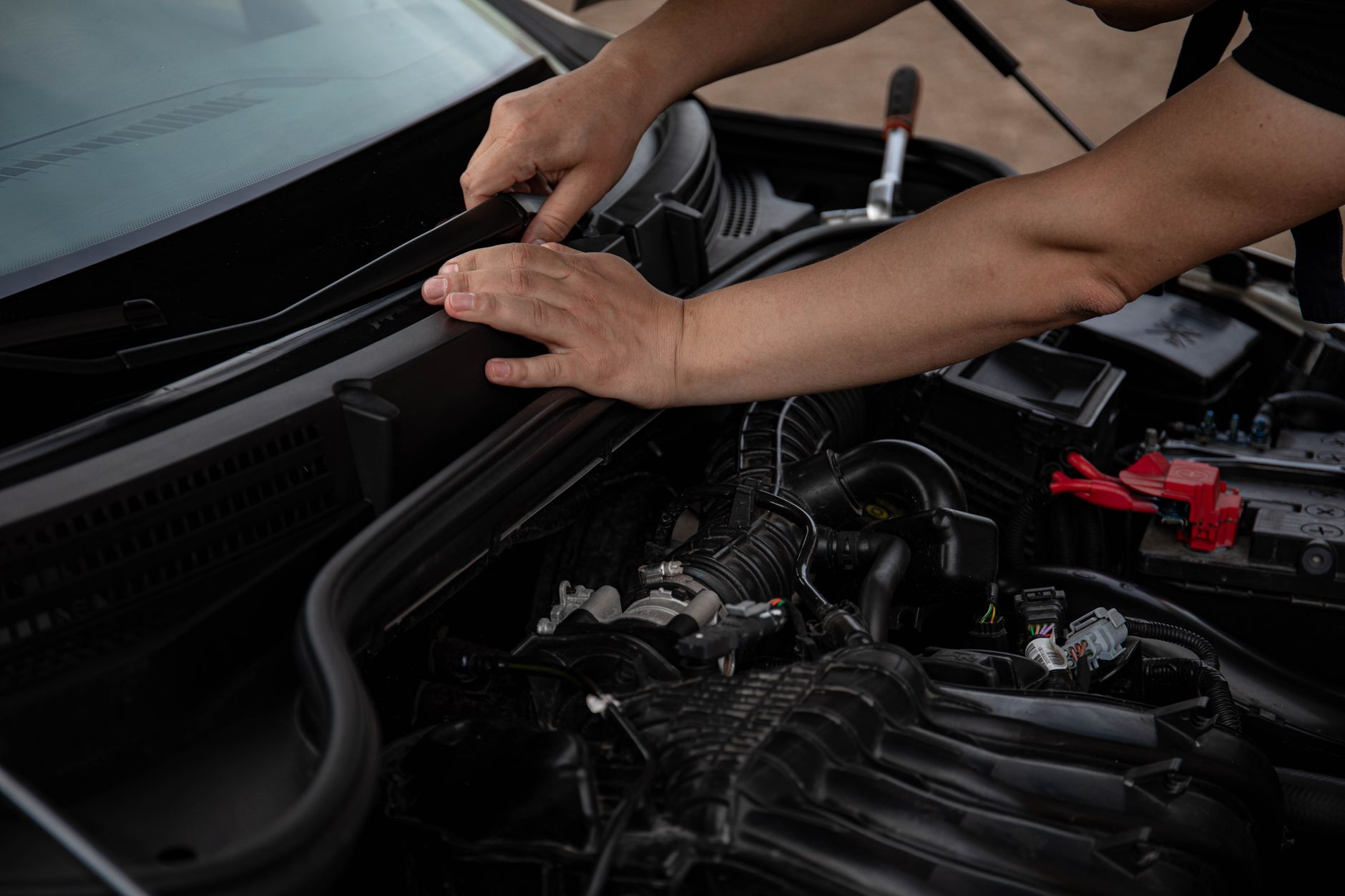 Close-up of mechanic hands fixing a car windshield wiper, showcasing engine components. — Selecting the best Maintenance Stra