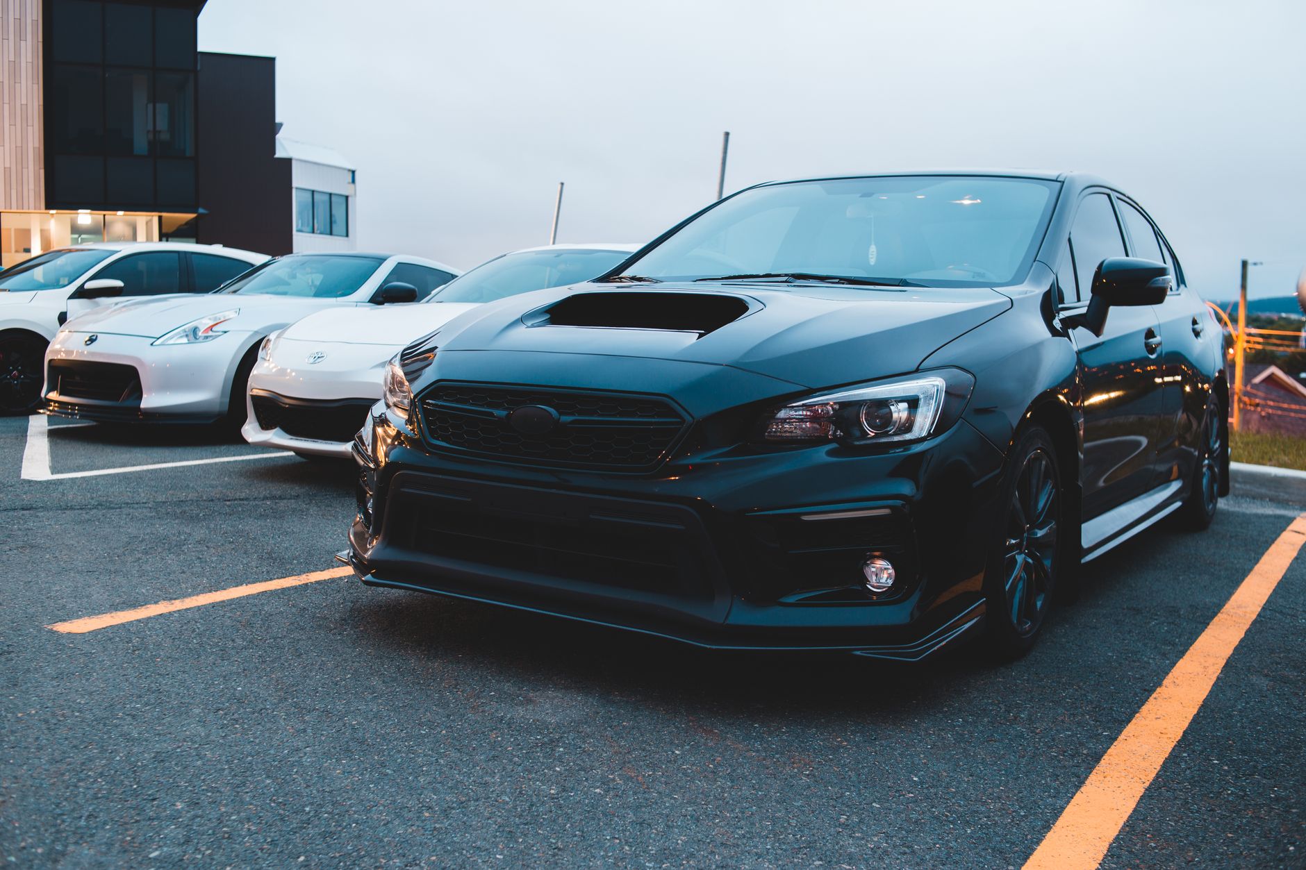Powerful black automobile with massive hood standing near modern racing white cars on asphalt parking lots — Signs of Trouble
