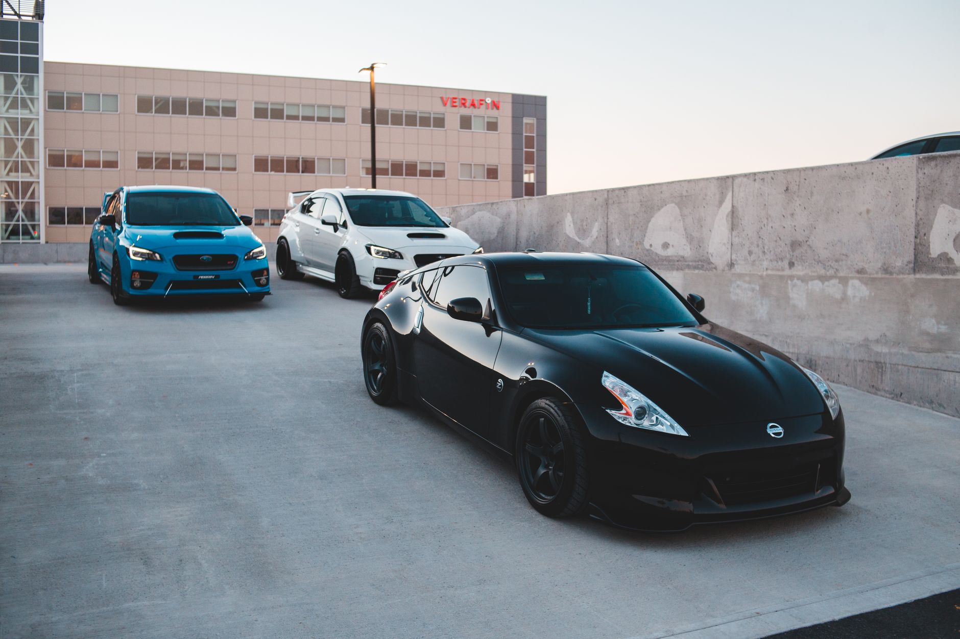 Sports cars parked on concrete road near wall against non residential building and clear sky at sunset — Tips for Maintaining