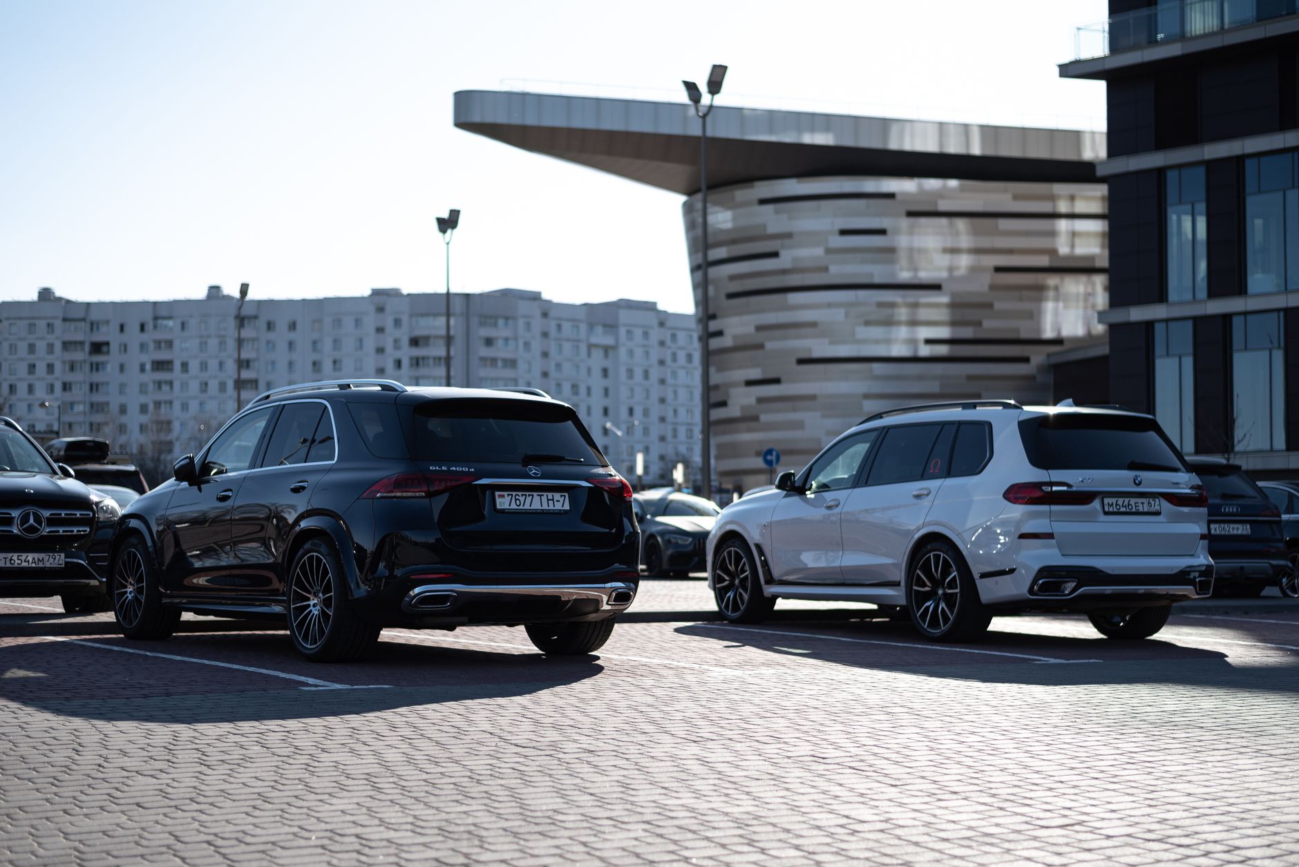 Two luxury SUVs parked in an urban setting with modern buildings in the background. — Tips to Appoint An Auto Locksmith for R