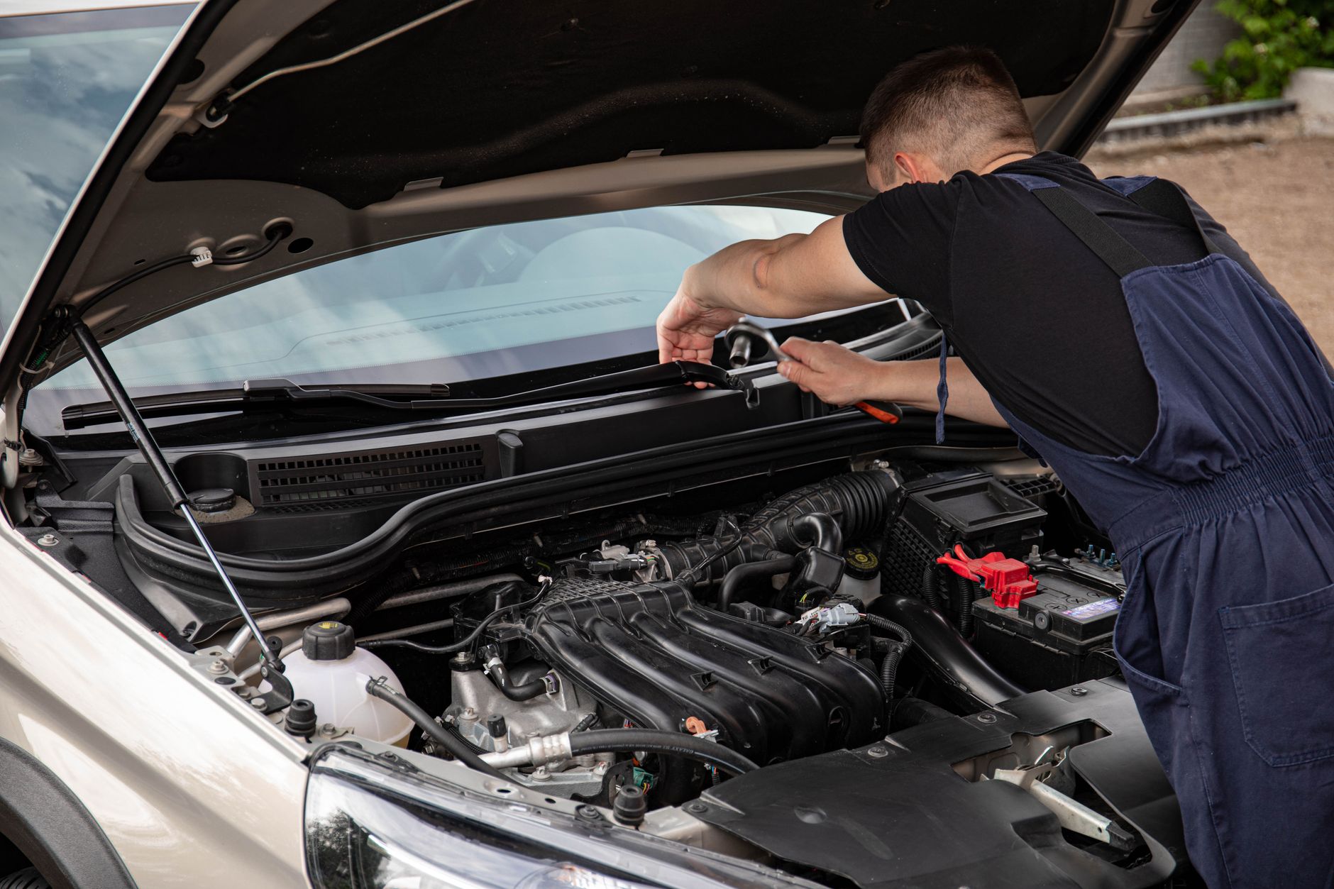 A mechanic uses tools to repair a car engine outdoors in daylight. — To Exchange in order to Repair Your Car windows, Thatrrr