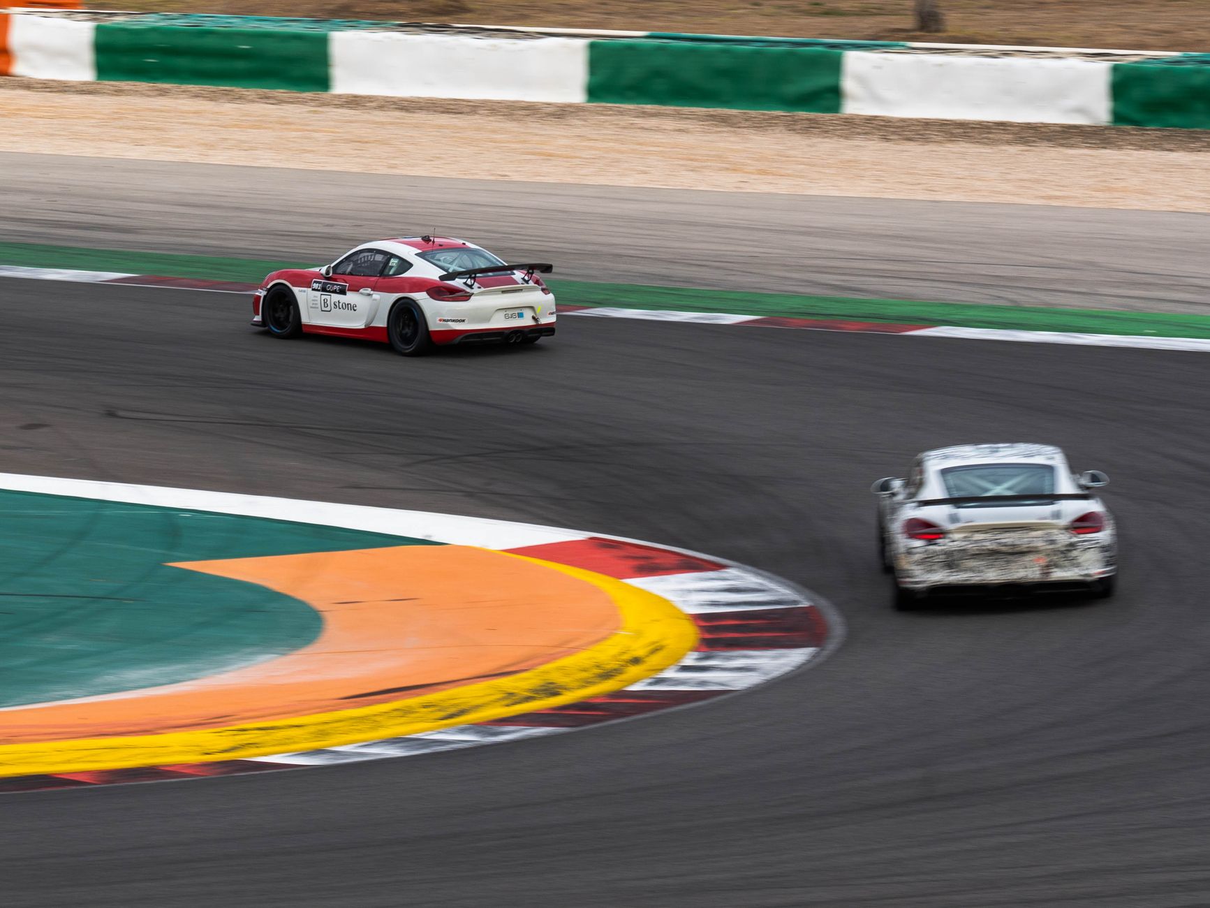 Two race cars navigate a sharp turn on a professional track, capturing the essence of motorsport speed. — Towing truck a very