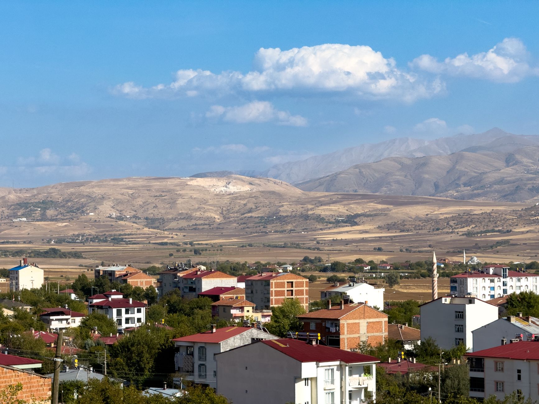 A picturesque view of Kovancılar, Elazığ with red-roofed houses and mountain landscape. — Weekly Cashback Offers on OK Win Ap