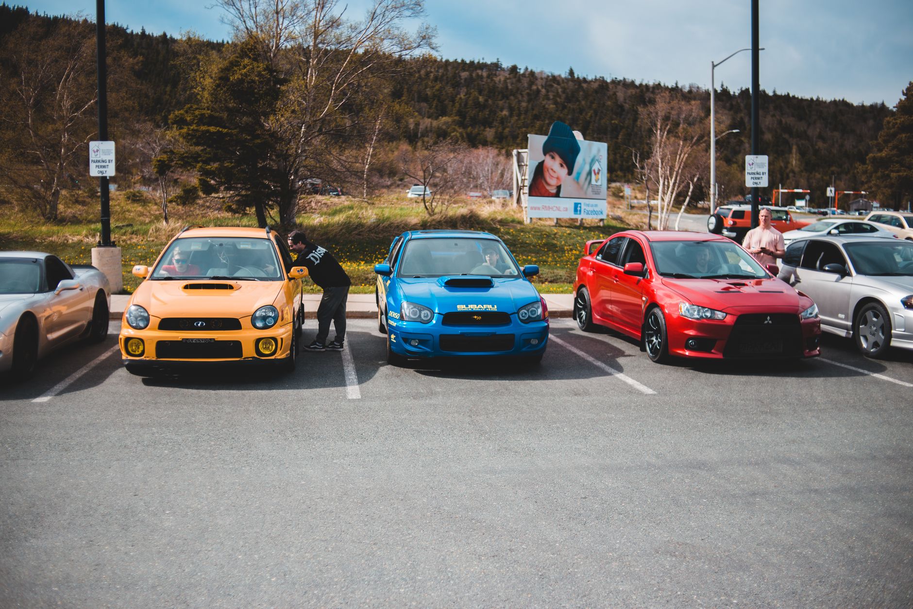 Colorful cars showcased outdoors in an urban parking lot on a sunny day. — Why Rent a Lease Return Truck