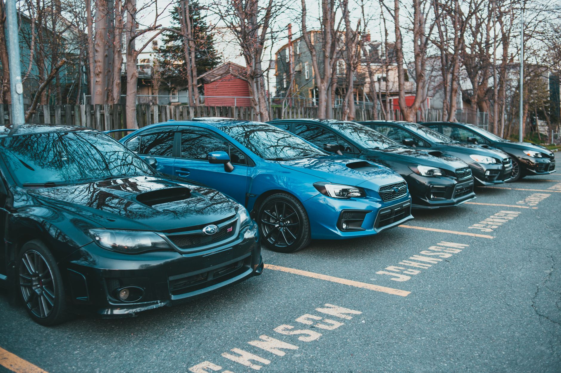 Multiple Subaru cars parked in an outdoor lot lined with trees, showcasing automotive design. — Why will you be towed?